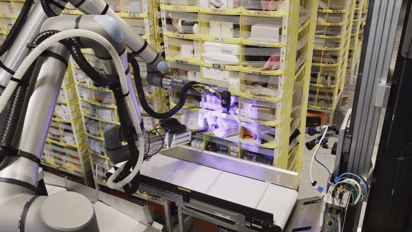 Amazon's Vulcan robotic system reaching into a densely packed warehouse storage pod