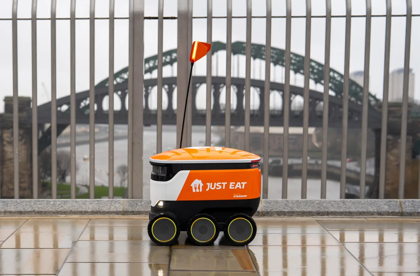 A Starship sidewalk delivery robot carrying Just Eat branding near Sydney Harbour